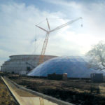 Image of a 206 foot diameter by 60 foot height IFR with GEO Domes erection with the dome laying next to the tank with crane
